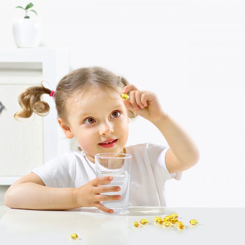 child, who suffers from ADHD, looking at omega 3 Capsules